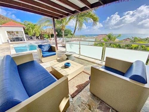 a living room with a couch and a swimming pool at Villa Zen, luxury and confort, private pool and sea view in Cul de Sac