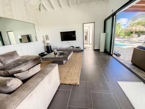 a living room with a couch and a television at Villa Zen, luxury and confort, private pool and sea view in Cul de Sac