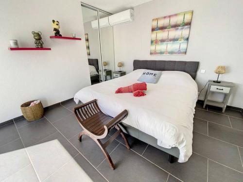 a bedroom with a bed with white sheets and a chair at Villa Zen, luxury and confort, private pool and sea view in Cul de Sac