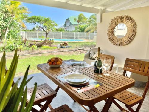una mesa de madera con un bol de fruta en el patio en Maracuja 4, Orient Bay village, walkable beach at 100m, en Orient Bay