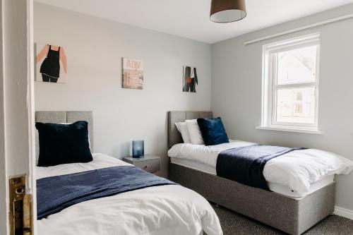 a bedroom with two beds and a window at Central Apartment Newcastle in Newcastle