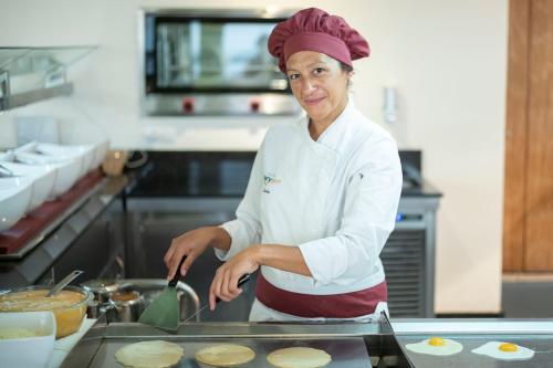 a woman in a kitchen preparing food at Hotel Ivory Playa Sports & Spa in Port d'Alcudia