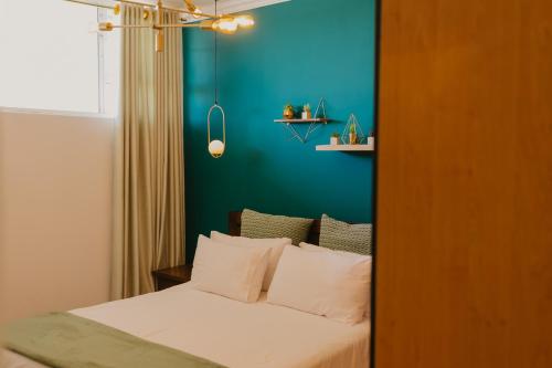 a bedroom with a bed with a blue wall at Lescalier Cabanas 511 in Amanzimtoti
