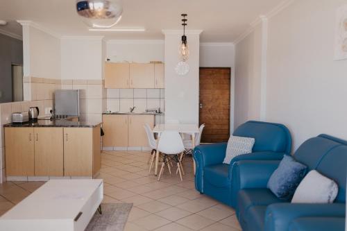 un soggiorno con divano blu e una cucina di Lescalier Cabanas 511 ad Amanzimtoti