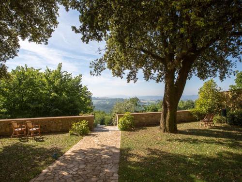 a tree and two chairs sitting under a tree at Relais Villa Sensano in Pignano