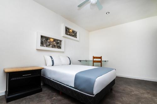 Cama o camas de una habitación en Capital O Hotel Joyma Suites, San Luis
