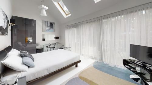a bedroom with a bed and a large window at South Lodge in Milton Keynes