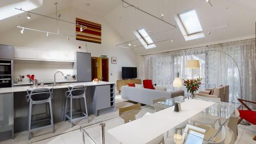 a kitchen and living room with red chairs and a table at South Lodge in Milton Keynes