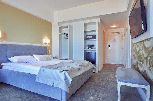 a bedroom with a large bed and a television at Continental Forum Constanta in Constanţa