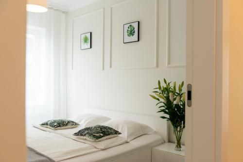a bedroom with white walls and a bed with pillows at Platinum Towers Central Apartments in Warsaw