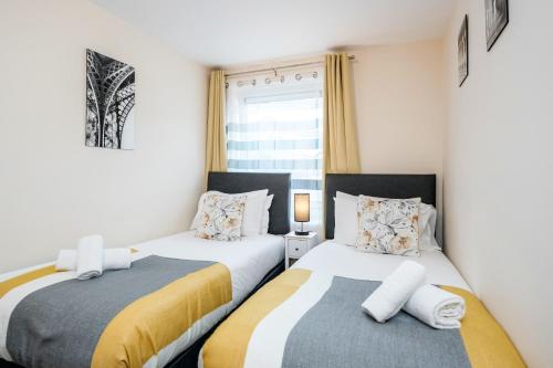 two beds in a small room with a window at MPL Apartments Watford-Croxley Biz Parks Corporate Lets 2 bed FREE Parking in Watford