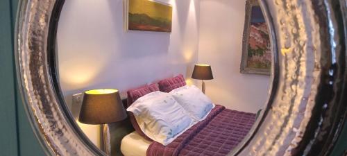 a mirror reflection of a bed in a room at Chambres et Tables d'hôtes du Puits d'Athie in Appoigny
