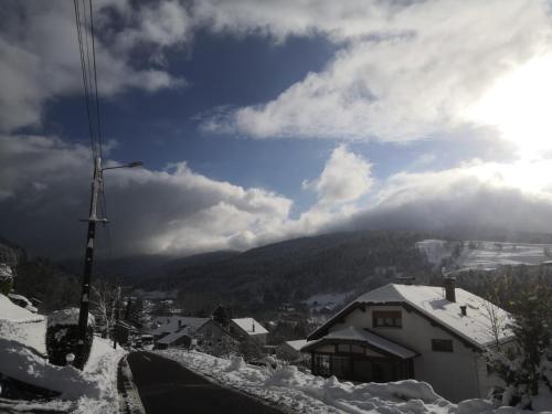 a snow covered street with a mountain in the background at Gîte de famille dans les Vosges in Saint-Maurice-sur-Moselle