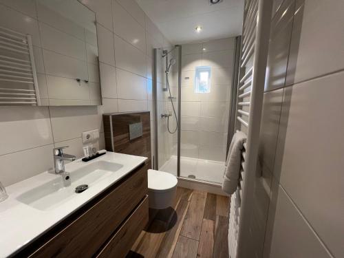 a bathroom with a sink and a shower at Hotel Nap in West-Terschelling