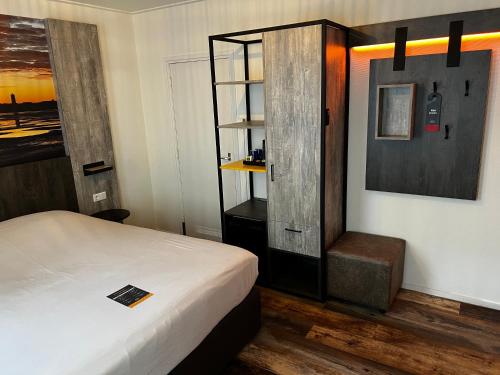 a bedroom with a bed and a book shelf at Hotel Nap in West-Terschelling