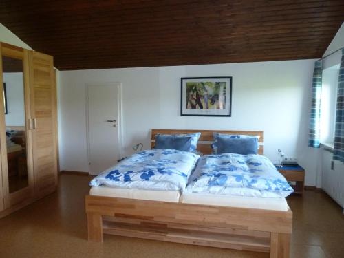 a bedroom with a large bed with blue pillows at Ferienwohnung Dachs in Zachenberg