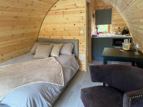 1 dormitorio con 1 cama y 1 silla en una habitación en Fernhill Valley Farm, en Blaencwm