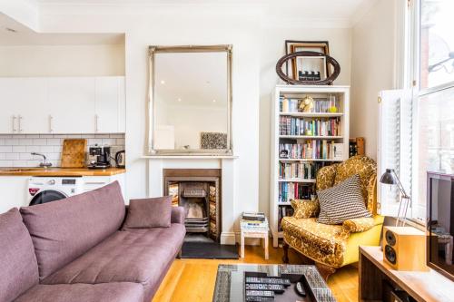 倫敦的住宿－Bright and Spacious Notting Hill Nest，带沙发和壁炉的客厅