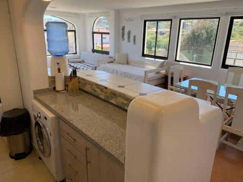 Una cocina y una sala de estar con un sofá y una mesa. en Bahía de Rosas frente al mar Algarrobo Norte, en Algarrobo