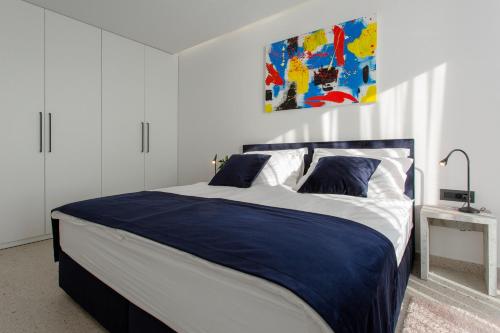 a bedroom with a large bed with blue and white sheets at Villa Dispet, sea view, pool, jacuzzi, sauna, cinema in Omiš