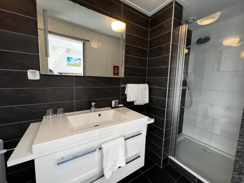 a bathroom with a sink and a shower at Hotel Nap in West-Terschelling