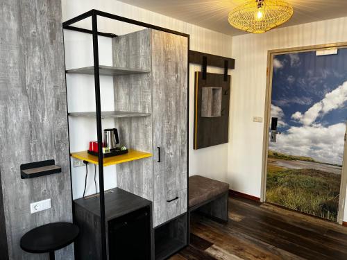 a room with a book shelf and a wooden door at Hotel Nap in West-Terschelling
