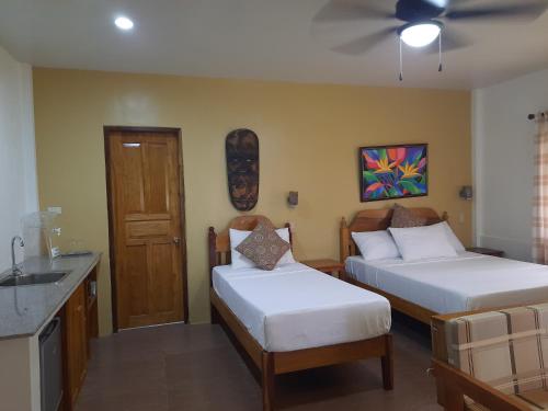 a hotel room with two beds and a sink at Eastwind Beach Club- El Nido in El Nido