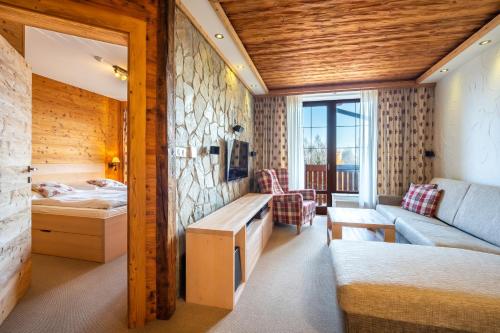 ein Zimmer mit einem Bett und einem Sofa in einem Zimmer in der Unterkunft Kukučka Lomnica - Tatranská Lomnica in Tatranská Lomnica
