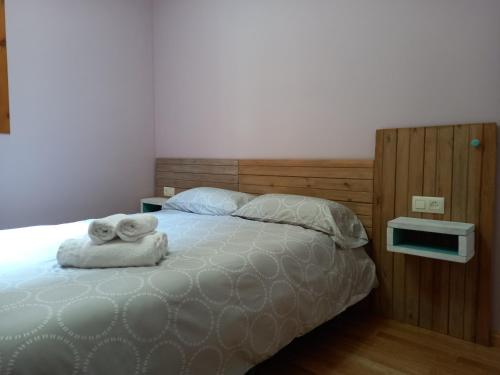 1 dormitorio con 1 cama con toallas en Apartamentos Tuara, en Castejón de Sos