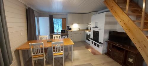a kitchen with a wooden table and a dining room at Hillside Cottage in Ivalo