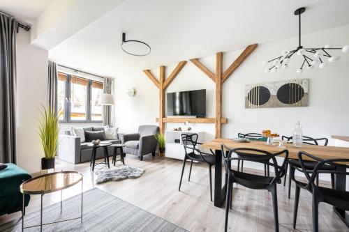 a dining room and living room with a table and chairs at Apartament Onyks in Zakopane