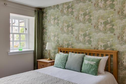 a bedroom with a bed with a floral wallpaper at Balgavies Home Farm - Cottage in Forfar