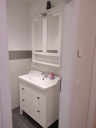a white bathroom with a sink and a mirror at Villa Ruge in Glowe