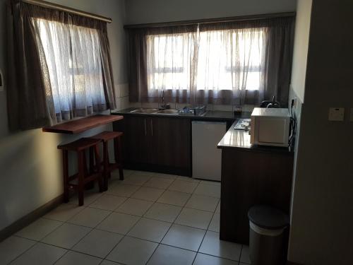 a small kitchen with a sink and a microwave at Tlou Safari Lodge in Kasane