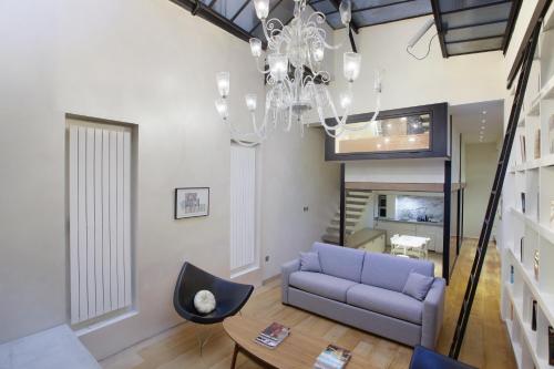 a living room with a purple couch and a chandelier at Loft center of Paris by Studio prestige in Paris