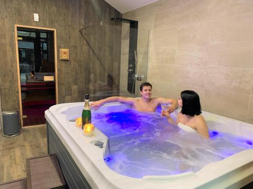un hombre y una mujer en una bañera en Waterfront Lodge en Dunapataj