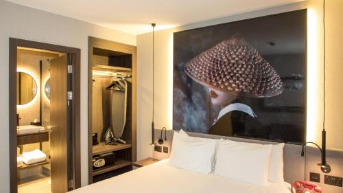 a hotel room with a bed with a picture of a woman at Radisson RED London Greenwich The O2 in London