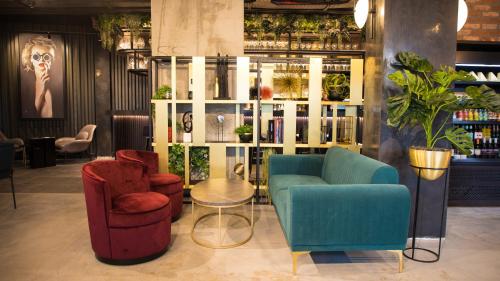 a lobby with two chairs and a table and chairs at Radisson RED London Greenwich The O2 in London