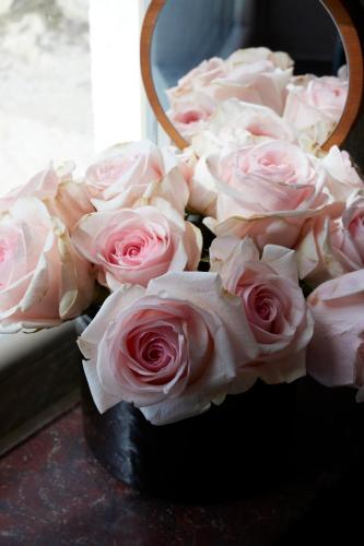 a bouquet of pink roses in a mirror at Santorini Sky, The Lodge in Pirgos