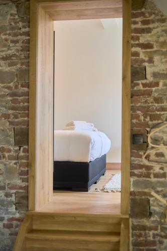 a bedroom with a bed in a brick wall at Château de la Chapelle in Anthisnes