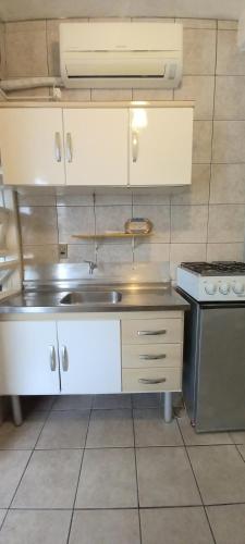 a kitchen with a sink and a stove at Pousada Moradas da Praia in Garopaba