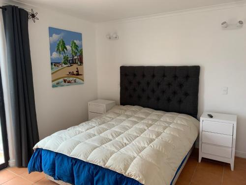 Un dormitorio con una cama grande con cabecero negro. en Bahía de Rosas frente al mar Algarrobo Norte, en Algarrobo