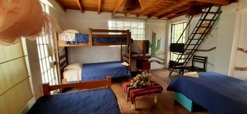 a room with two bunk beds and a television at Cabañas o habitación en Fundo Huabayor in Lima