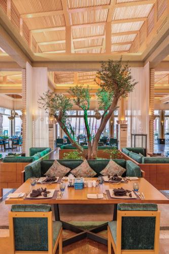 a dining room with a table and a tree at Rixos Premium Seagate in Sharm El Sheikh