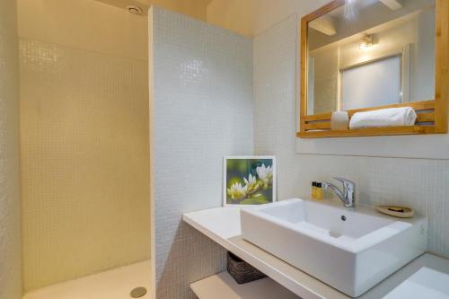 une salle de bain blanche avec un lavabo et un miroir dans l'établissement Observance 2 bedroom duplex apartment, à Bordeaux