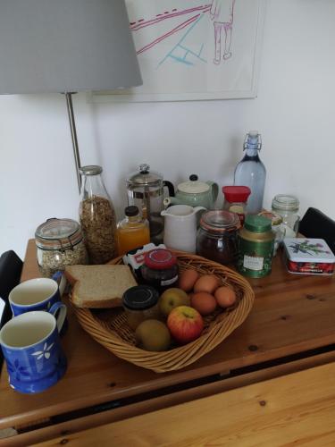 a table with a basket of fruit and other food at Offa Hideaway in Leamington Spa
