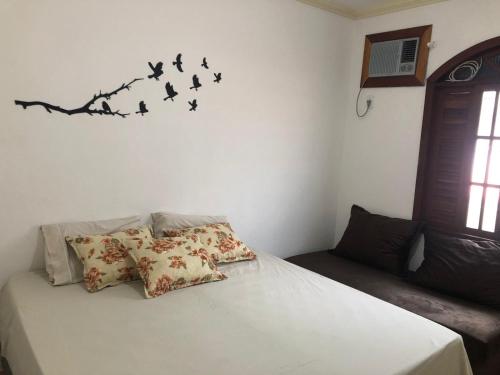 a bedroom with a bed with birds on the wall at Jo´s Apartment in Porto Seguro