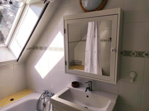 W łazience znajduje się umywalka, lustro i wanna. w obiekcie Sunhouse, Balatonvilágos w mieście Balatonvilágos