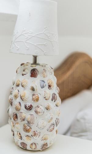 a glass vase with a lamp on a table at Fairlight - Charming coastal home on the beach in Chichester