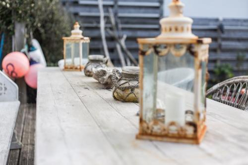 a table with three lanterns on top of it at Fairlight - Charming coastal home on the beach in Chichester